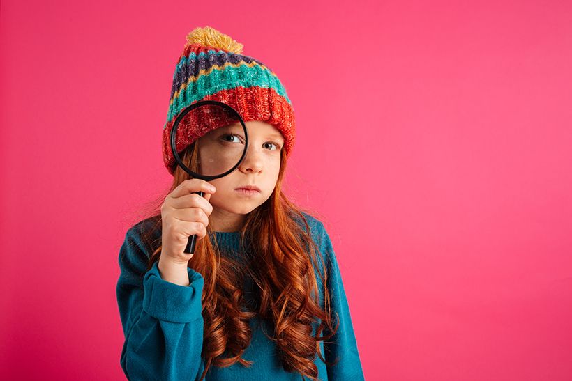 funny-serious-girl-looking-through-magnifying-glass-camera